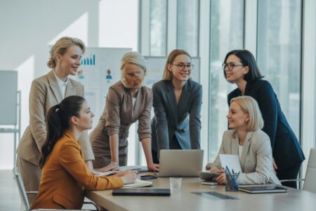 Grupo de mulheres diversas em uma reunião de trabalho em um escritório moderno, demonstrando liderança e colaboração.